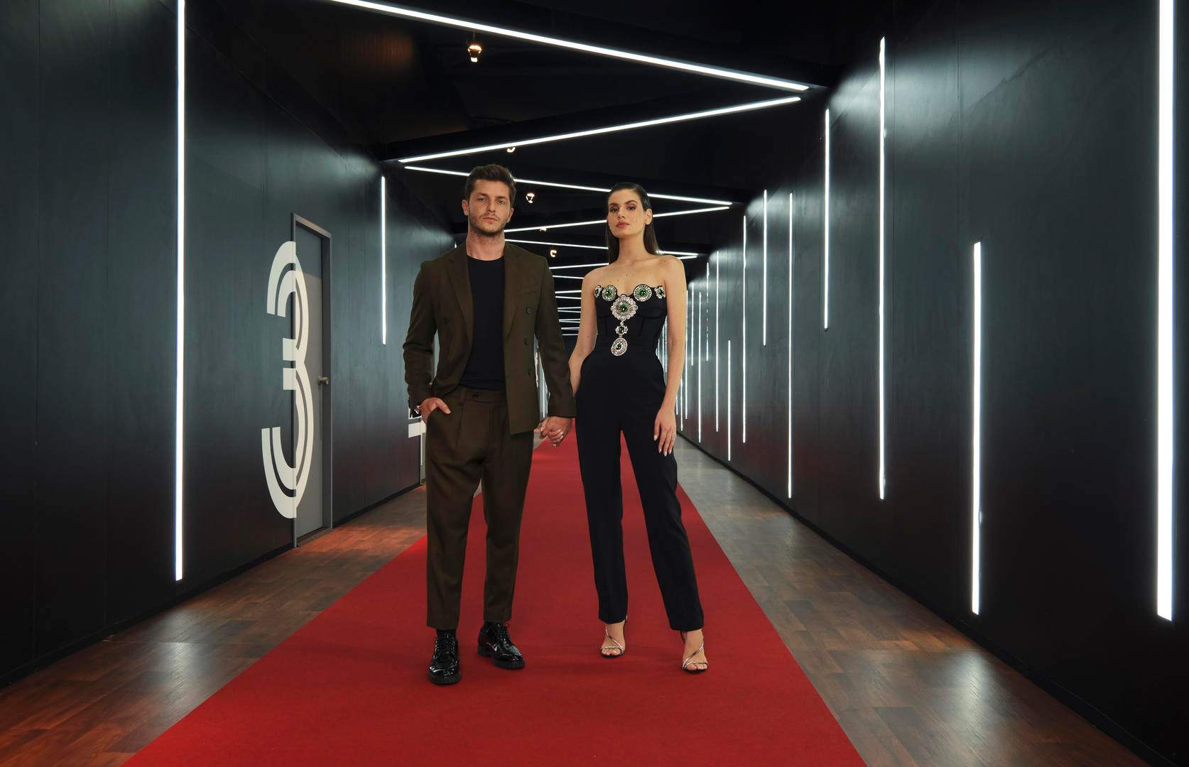 Camila Queiroz e Klebber Toledo ao lado das cabines de encontro do reality Casamento às Cegas