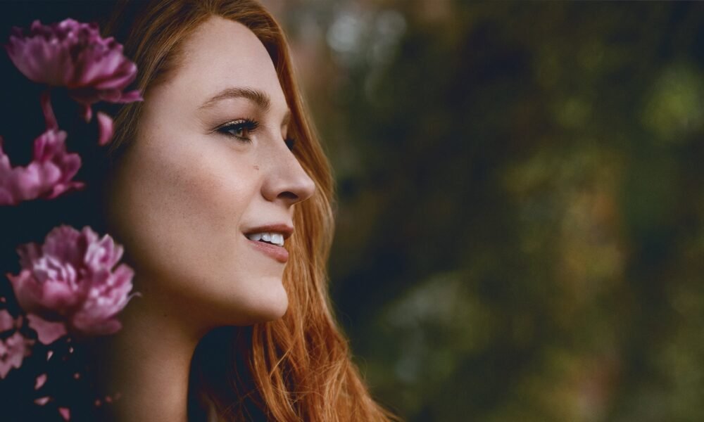 mulher ruiva em foto de perfil com uma flor no cabelo