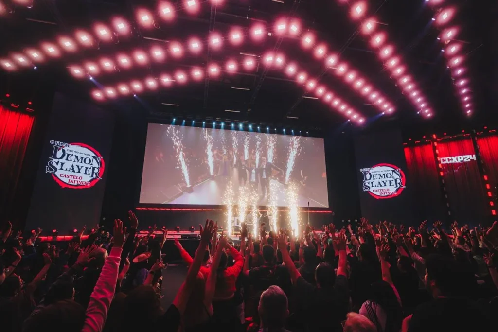 CCXP26 | Um Anel para Reunir os Fãs, o Soldado do Inferno para Invocar o Caos, Essa CCXP26 Promete uma Jornada Épica! 5 Fotografia do painel da Crunchyroll sobre Demon Slayer no Palco Thunder, domingo da CCXP24. No exato momento da captura da foto há uma pirotecnia no palco.