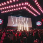Fotografia do painel da Crunchyroll sobre Demon Slayer no Palco Thunder, domingo da CCXP24. No exato momento da captura da foto há uma pirotecnia no palco.