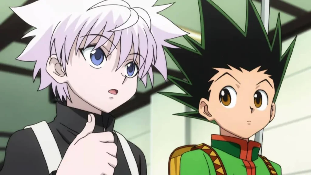 10 Animes na Netflix que Você Não Pode Perder 8 Killua Zoldyck e Gon Freecss, da esquerda para a direita, do anime Hunter x Hunter. Killua olha para um outro personagem à direita da câmera, enquanto Gon olha para Killua falando.