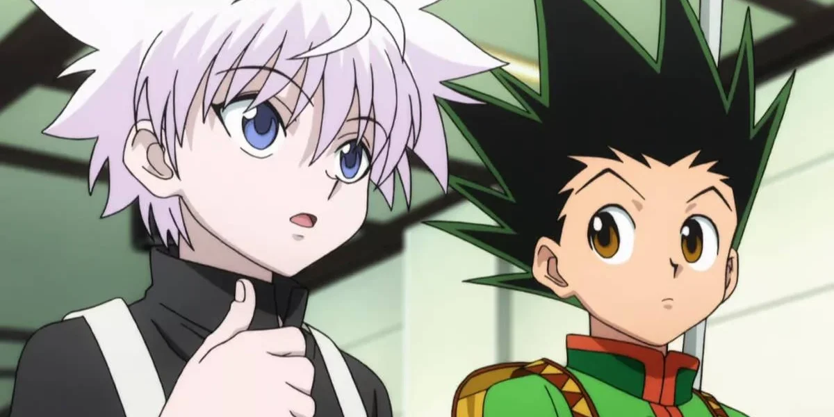 Killua Zoldyck e Gon Freecss, da esquerda para a direita, do anime Hunter x Hunter. Killua olha para um outro personagem à direita da câmera, enquanto Gon olha para Killua falando.