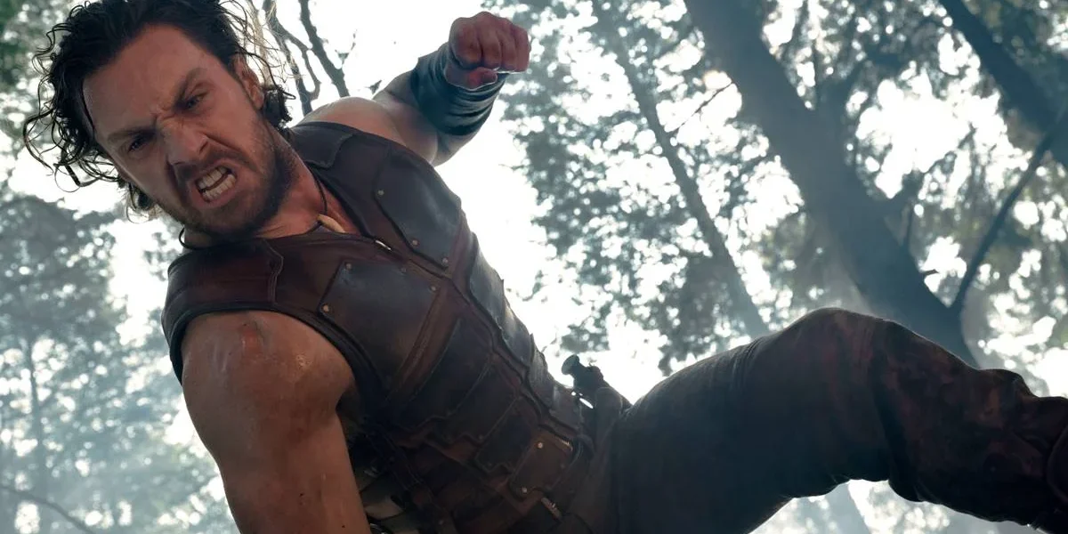 Aaron Taylor-Johnson como "Kraven, o Caçador", em filme homônimo de 2024. O anti-herói está dando socos em alguém, a câmera é vista de baixo para cima.