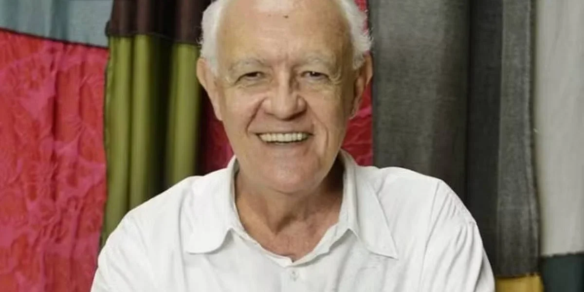 Ney Latorraca Morre aos 80 anos no Rio de Janeiro Fotografia frontal com ator Ney Latorraca sorrindo para a câmera, vestido todo de branco, já idoso.