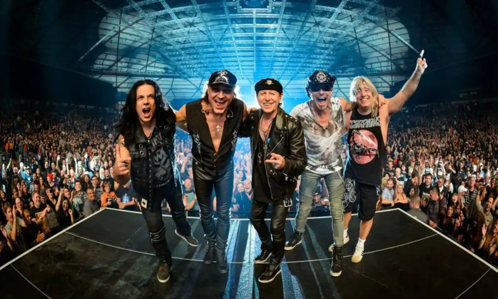 Imagem dos membros da banda Scorpion em foto comemorativa pós-apresentação, de costas para o palco tirando selfie.