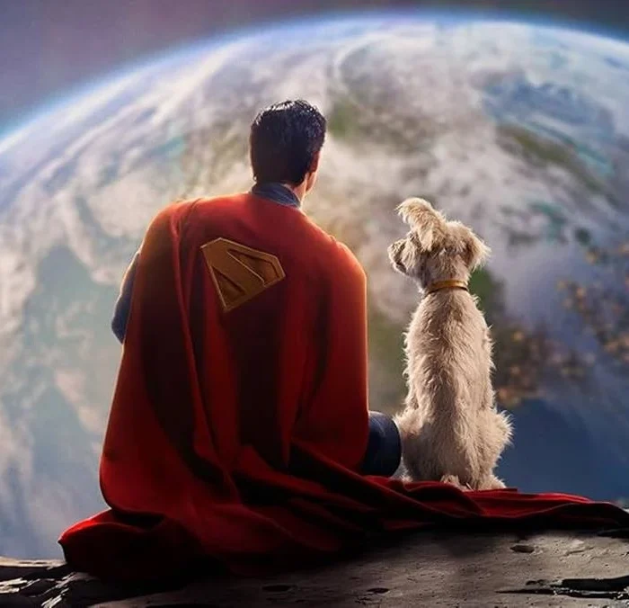 Imagem promocional para o filme "Superman" (2025), de James Gunn. O homem de aço e seu cão, Krypto, estão de costas para nós, sentados na Lua, e olhando para a Terra. Superman está com seu icônico visual azul com a longa capa vermelha e símbolo "S" marcado em amarelo na capa.