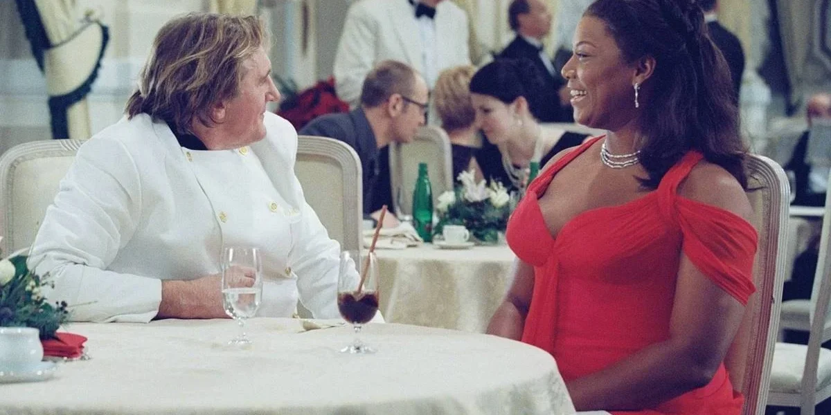 Sessão da Tarde Hoje | Saiba Qual Filme Será Exibido Nesta Quinta-Feira, 30 de Janeiro Queen Latifah sentada em uma mesa de gala em "As Férias da Minha Vida" (2006)