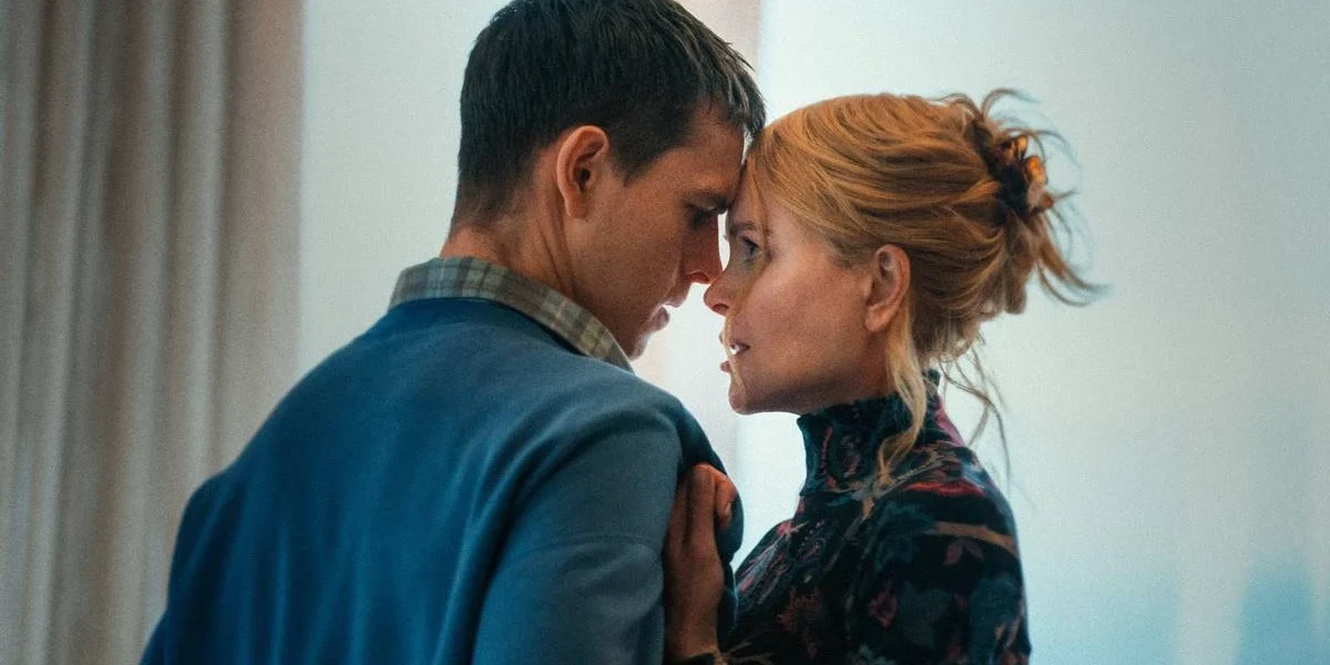 Samuel (Harris Dickinson) e Rony (Nicole Kidman), respectivamente à esquerda e direita, centralizados na câmera. Ela puxa-o pela blusa e suas testas estão se encostando.