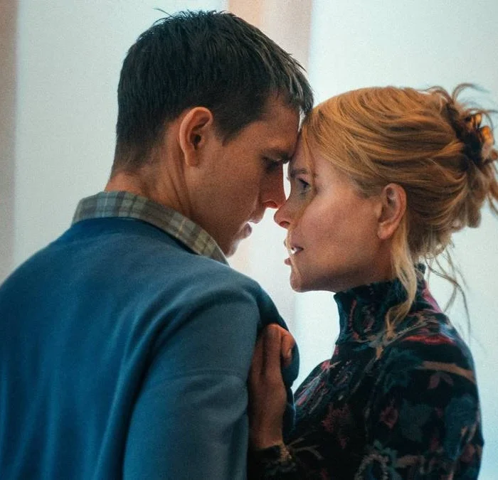 Samuel (Harris Dickinson) e Rony (Nicole Kidman), respectivamente à esquerda e direita, centralizados na câmera. Ela puxa-o pela blusa e suas testas estão se encostando.