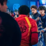 Miguel e Robby de Cobra Kai (Netflix) em destaque enfrentando, junto com companheiros, inimigos com traje de karate.