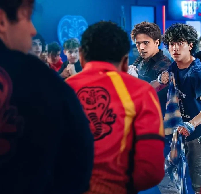 Miguel e Robby de Cobra Kai (Netflix) em destaque enfrentando, junto com companheiros, inimigos com traje de karate.