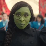 Cillian Murphy não aparece em “Extermínio: A Evolução”, Garante Produtor Cynthia Erivo como a protagonista Elphaba de "The Wicked", filme um. A personagem de pele verde está com seus óculos de lentes redondas e com um sorriso discreto à câmera.
