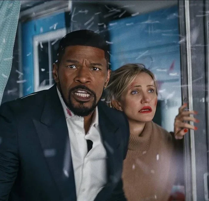 Jamie Fox, esquerda, e Cameron Diaz, direita, com a janela aberta e semblantes preocupados. Entra neve pela janela. Eles interpretam seus personagens de "De Volta a Ação" (2025).