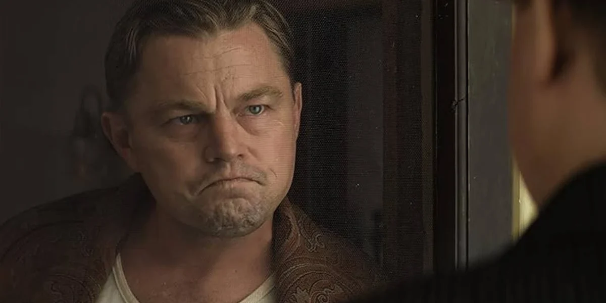 Leonardo DiCaprio Contribui com US$ 1 Milhão para Combate a Incêndios na Califórnia Leonardo DiCaprio interpretando Ernest Burkhart no longa "Assassinos da Lua das Flores" (ou "Killers of the Flower Moon" (2023). Ator está enquadrado em destaque à esquerda e olhando sério para outro personagem, de costas para nós.