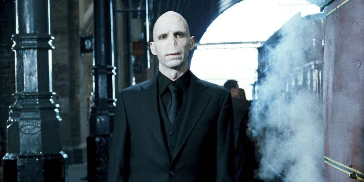 Ralph Fiennes como Lord Voldemort em "Harry Potter e a Ordem da Fênix" (2007). Personagem está centralizado em uma estação de trem.