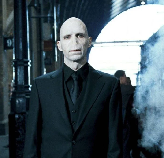 Ralph Fiennes como Lord Voldemort em "Harry Potter e a Ordem da Fênix" (2007). Personagem está centralizado em uma estação de trem.