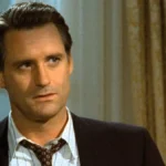 Bill Pullman como o presidente de Independence Day (1996). Há uma bandeira dos EUA ao seu fundo, à direita.