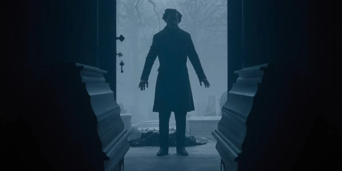 Porta aberta, com silhueta ao fundo, e dois caixões em destaque, no longa "Nosferatu" (2024), de Eggers.