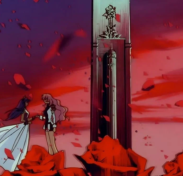 Utena e Anthy, à esquerda, meio a um campo de rosas com pétalas esvoaçantes em um fim de tarde no anime "Shoujo Kakumei Utena".