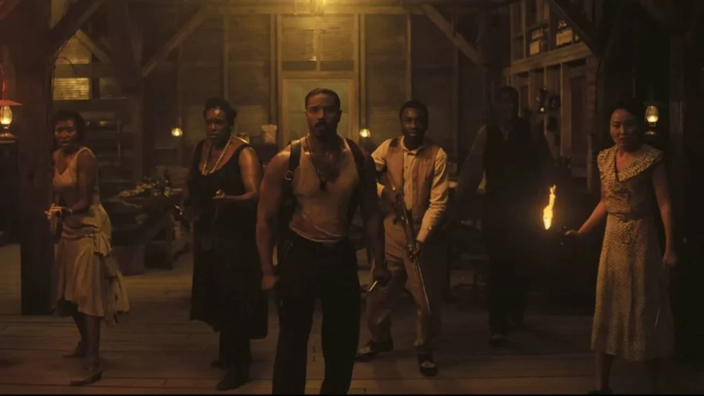 Elenco de Sinners interpretando seus personagens no lonca de terror de vampiros. Os personagens estão caracterizados com roupas da década de 30 em um casebre na Louisiana. Michael Jordan está ao centro, todos estão com semblante assustado e armados.