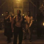 Papa Francisco | 5 Filmes sobre Papas, Freiras ou Vaticano Elenco de Sinners interpretando seus personagens no lonca de terror de vampiros. Os personagens estão caracterizados com roupas da década de 30 em um casebre na Louisiana. Michael Jordan está ao centro, todos estão com semblante assustado e armados.