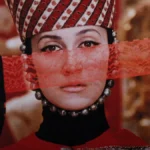 Mulher com vestes típicos armênios, segurnado um véu vermelho como parte de sua roupa. Cena de "The Color of Pomegranates" (1969).