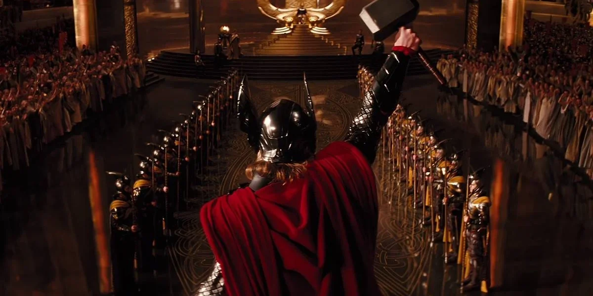 Sessão da Tarde Hoje | Saiba Qual Filme Será Exibido Nesta Sexta-feira, 31 de Janeiro Thor erguendo seu martelo em "Thor" (2011), centraliado na tela e com capacete de Asgard e capa vermelha.