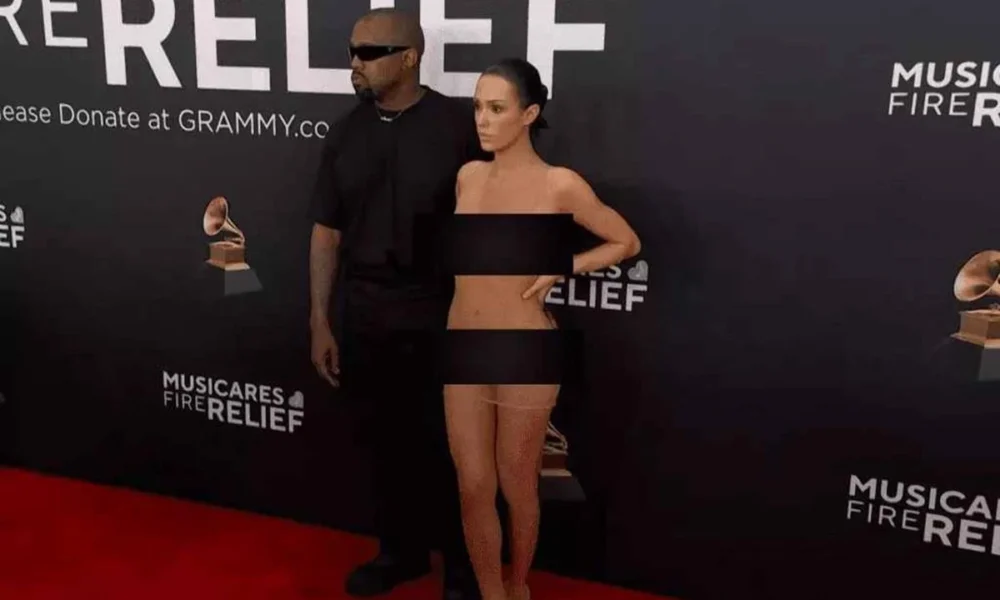 Artista de joias e esposa de Kanye West, Bianca Censori, desfilando no Grammy. Ela está com um vestido completamente transparente. A imagem está coberta com tapa sexos.