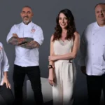 Helena Rizzo, Henrique Fogaça, Ana Paula Padrão, e Érick Jacquin posando para foto promocional do Masterchef. Fundo cinza. Chefes estão de dólmã e a apresentadora com um vestido branco.