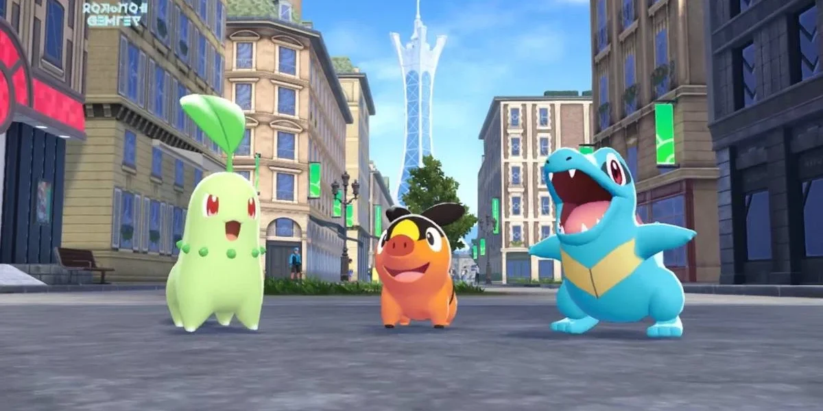 Os três iniciais em "Pokémon: Legends A-Z": Chikorita, Tepig, Totodile, no meio de uma rua em Lumiose.