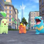 Os três iniciais em "Pokémon: Legends A-Z": Chikorita, Tepig, Totodile, no meio de uma rua em Lumiose.