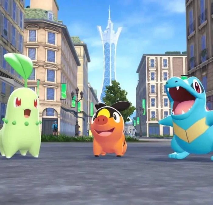 Os três iniciais em "Pokémon: Legends A-Z": Chikorita, Tepig, Totodile, no meio de uma rua em Lumiose.