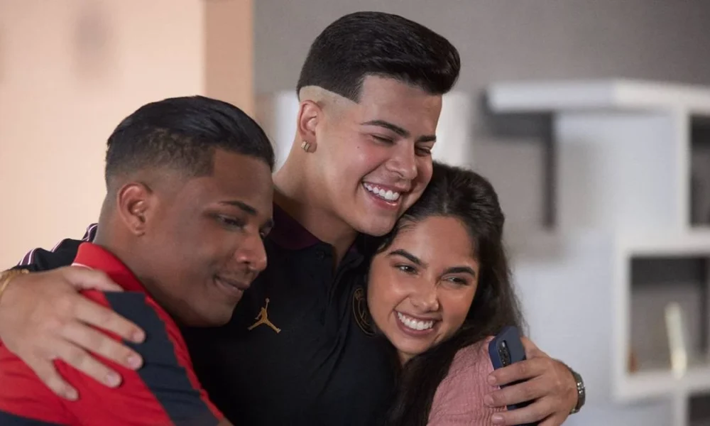 Nando (Christian Malheiros), Doni (Jotappê), Rita (Bruna Mascarenhas) se abraçando na série "Sintonia", da Netflix.