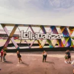 Reacher | 3ª Temporada e a Consolidação de Um Sucesso Vista para um logo do Lollapalooza gigante no festival, especificamente na edição de 2025.