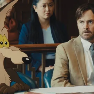 Coiote ao lado de seu advogado no filme "Coiote vs. Acme". Imagem mistura animação 2D com live-action.