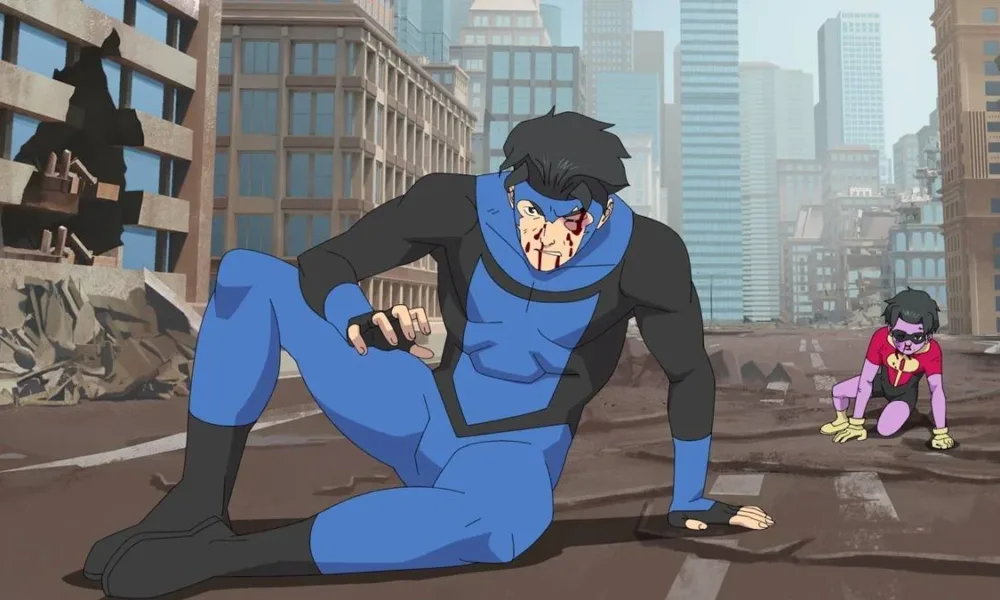 Mark da série animada "Invincible", temporada 3, em combate no meio da cidade. Ele está uniformizado, sangrando, e com a perna arqueada tentando se levantar. Atrás dele há um garoto uniformizado como Robin, também ferido.