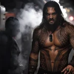 Jason Momoa como o Aquaman no filme homônimo de 2018. Ele está encarando um homem que está de costas para a câmera, há fumaça na tela, e podemos ver as tatuagens no tronco do personagem.