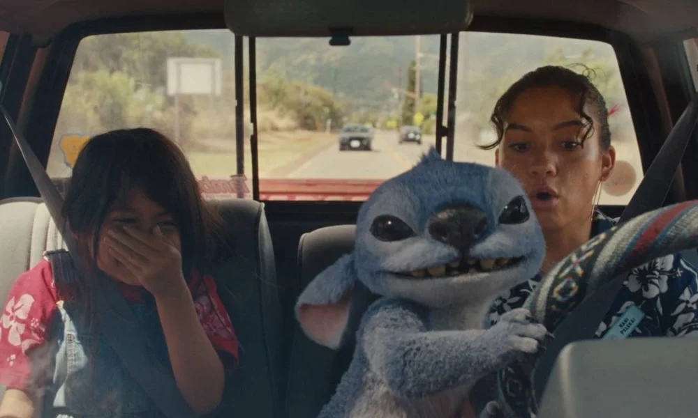 Lilo à esquerda, rindo, e Nani, à direita, preocupada, no volante, mas observando o alien Stitch dirigir o carro. Imagem do live-action de 2025 "Lilo & Stitch".