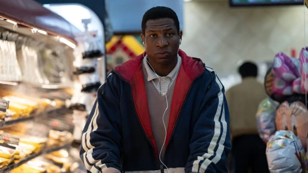 Kevin Feige Fala Sobre Futuro do MCU Após 2025 4 Jonathan Majors como o protagonista de "Magazine Dreams", com uma jaqueta andando em um mercado.