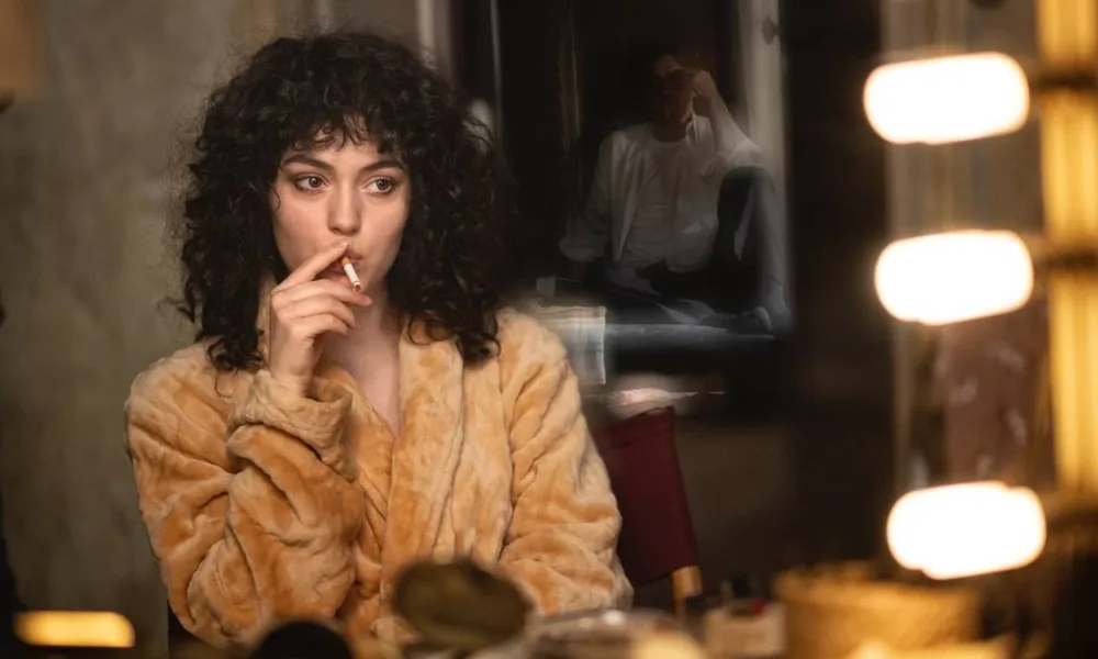 Anamaria Vartolomei como Maria Schneider em "Being Maria". Ela está em um camarim fumando.