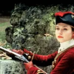 Elis Regina Faria 80 Anos Hoje e Segue Inesquecível Émilie Dequenne vestida com roupas vermelhas do século XVIII e empunhando uma arma. Imagem do filme "O Pacto dos Lobos".