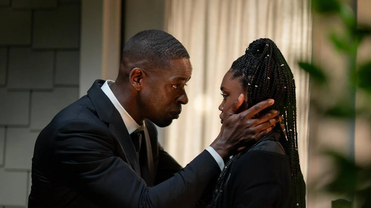 Paradise (2025) | Conspirações, Drama e Alteração da Realidade 2 Sterling K. Brown (esquerda) e Aliyah Mastin (direita) fazendo papel de pai e filha na série "Paradise". Ele está de terno, curvado, olhando a filha nos olhos enquanto coloca suas mãos na nuca em conforto.