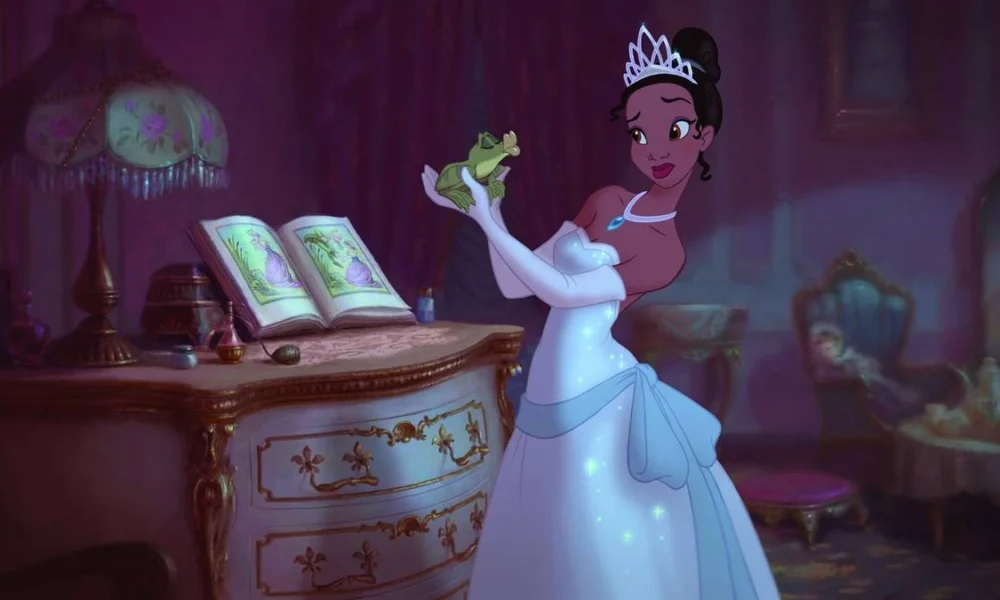 Tiana segurando o príncipe Naveen, na forma sapo, no filme "A Princesa e o Sapo", de 2009. Ela está em um quarto com mobiliário da época.