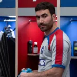 Brett Goldstein no episódio 9 da primeira temporada de "Ted Lasso" interpretando Roy Kent. Ele está num vestiário, com camisa de time, e um olhar dissimulado.