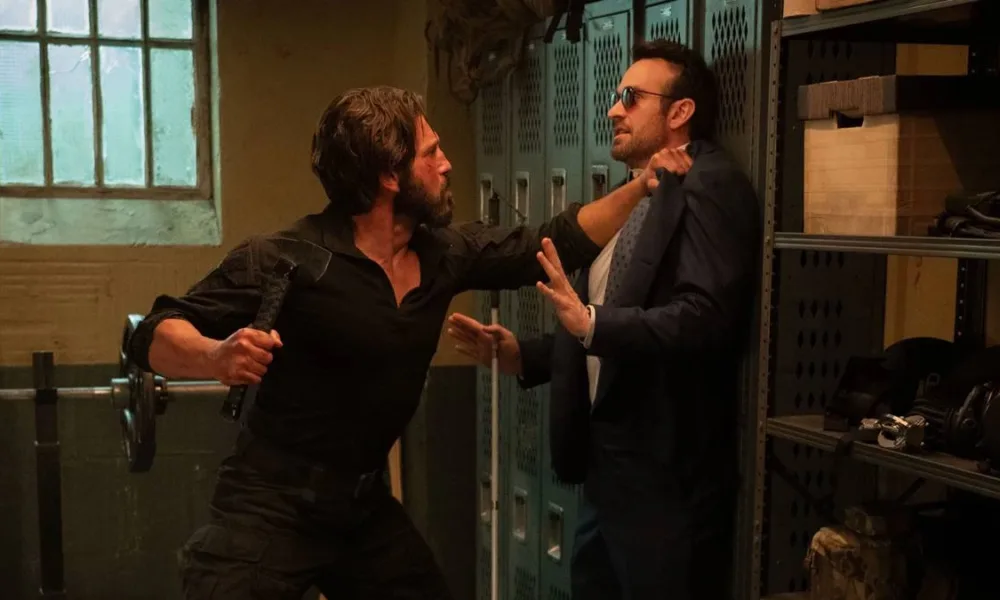 O Demolidor sendo pego pelo colarinho por um ladrão de banco. Imagem do 4º episódio da primeira temporada de "Demolidor: Renascido".