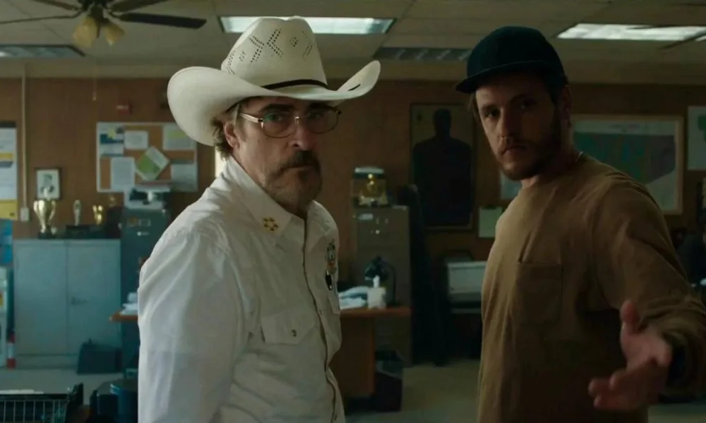 Protagonistas de "Eddington" em um escritório.