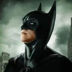 Val Kilmer como o Batman de "Batman para Sempre", olhando para o céu cinza de Gotham.