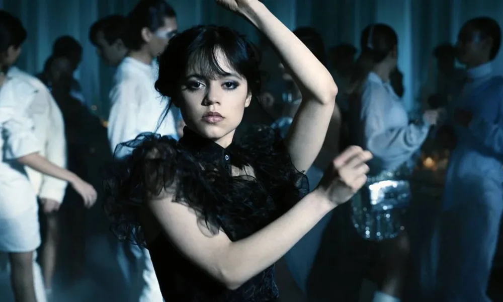 Jenna Ortega como Wandinha Addams na série "Wandinha". Imagem é a cena em que a protagonista dança "Marry The Night", de Lady Gaga, com um vestido preto.