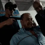 Personagem de Leandro Faria em "Do Sul, A Vingança" com uma arma na cabeça, sendo mantido refém, enquanto amarrado no filme.