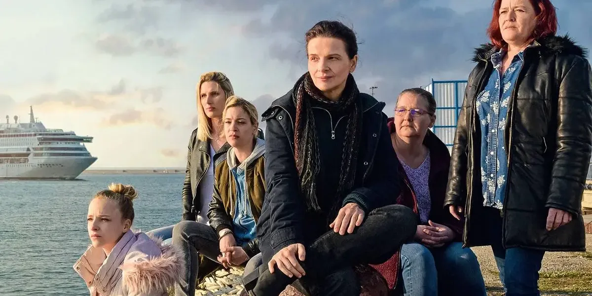 Elenco do filme francês "Entre Dois Mundos" (2022) sentado em um cais.